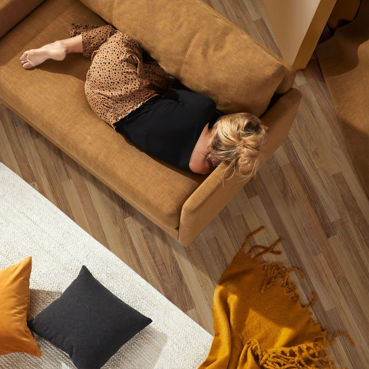 Kvinne ligger og hviler i sofaen